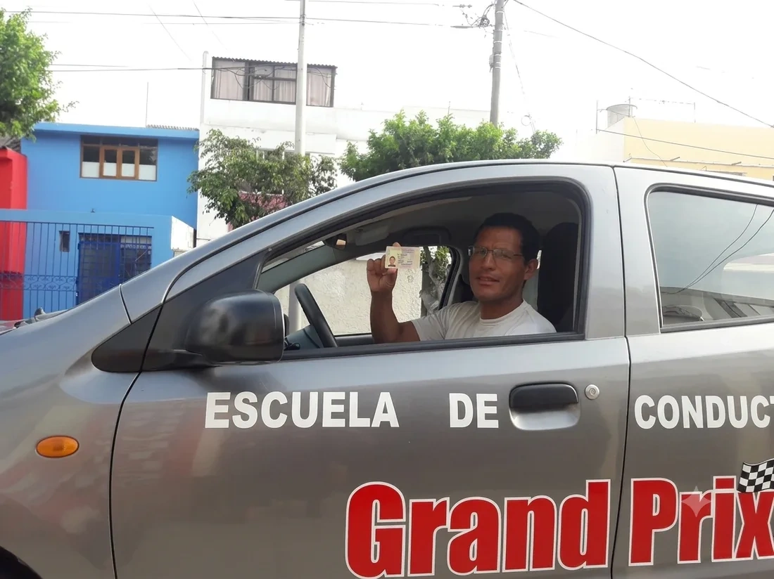 Alumno de Grand Prix mostrando su brevete recién obtenido, listo para el traslado