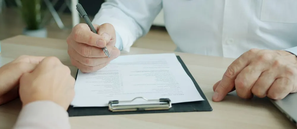 Médico llenando la evaluación del examen médico frente al postulante